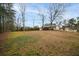 Large backyard featuring a mix of grass and moss, surrounded by mature trees and fencing at 3308 Wildwood Sw Dr, Marietta, GA 30060