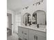 Bathroom with dual vanity, framed mirrors, and modern lighting fixtures at 3308 Wildwood Sw Dr, Marietta, GA 30060