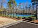 Well-maintained tennis court with chain link fence, surrounded by lush greenery at 4721 Talleybrook Nw Dr, Kennesaw, GA 30152