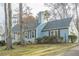 House exterior showcasing a light blue facade, neat landscaping, and a tree-lined street at 118 Knotts Landing Dr, Woodstock, GA 30188