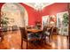 Formal dining room with hardwood floors, chandelier, and red accent wall at 130 Wesleyan Way, Oxford, GA 30054