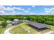 Wide shot of an outdoor equestrian facility with a covered arena, stables, and surrounding wooded areas at 8587 Seabiscuit Rd, Lithonia, GA 30058