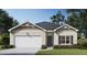 Charming single-story home with a two-car garage, gray door, and classic architectural details at 8587 Seabiscuit Rd, Lithonia, GA 30058