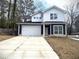 Two-story house with white and dark siding, a white garage door, and a long driveway at 2148 Lilac Ln, Decatur, GA 30032