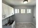 Bright laundry room with white cabinets and stainless steel sink at 2148 Lilac Ln, Decatur, GA 30032