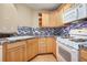 Well-equipped kitchen with light wood cabinets and tile backsplash at 4008 Orchard Hill Ter, Stone Mountain, GA 30083