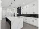 Modern kitchen with large island and marble countertops, open to living area at 744 Riverside Rd, Sugar Hill, GA 30518