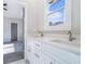 Bathroom with double vanity featuring white cabinets, countertop with a large window view at 1010 Nours Cir, Lawrenceville, GA 30045