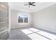 Bedroom bathed in sunlight with carpeted floor, ceiling fan, and a tray ceiling at 1010 Nours Cir, Lawrenceville, GA 30045