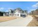 Spacious home with a large driveway and two-car garage, surrounded by mature trees and greenery at 1010 Nours Cir, Lawrenceville, GA 30045