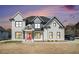 Stunning two-story home showcasing a modern design with black trim windows and a welcoming red front door at 1010 Nours Cir, Lawrenceville, GA 30045