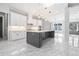 Modern white kitchen with gray island, stainless appliances and bright, marble floors at 1010 Nours Cir, Lawrenceville, GA 30045
