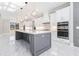 Modern white kitchen with gray island, stainless appliances and bright, marble floors at 1010 Nours Cir, Lawrenceville, GA 30045