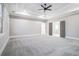 Cozy main bedroom with tray ceilings, ceiling fan, and large windows at 1010 Nours Cir, Lawrenceville, GA 30045