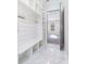 Mudroom with built in shelves, bench, and coat hooks with view to front door at 1010 Nours Cir, Lawrenceville, GA 30045