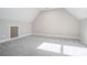 A room with a sloped ceiling, carpeted floor, and small window at 1010 Nours Cir, Lawrenceville, GA 30045