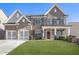 Brick two-story home with a three-car garage and manicured lawn at 4200 Oxcliffe Grv, Suwanee, GA 30024