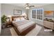 Virtually staged main bedroom with large window and wood bed frame at 169 Hunters, Mcdonough, GA 30253