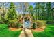 White gate opens to a tranquil backyard oasis with a pool and lush landscaping at 3382 Habersham Rd, Atlanta, GA 30305