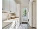 Bright laundry room with farmhouse sink, built-in cabinets, and access to backyard at 3382 Habersham Rd, Atlanta, GA 30305