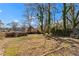 Large backyard with mature trees and a stone fire pit at 135 Adair Se Ave, Atlanta, GA 30315