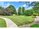 A picturesque backyard with a long, curved concrete walkway and surrounded by trees at 3505 Watson Rd, Cumming, GA 30028