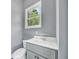 Cozy bathroom with a gray vanity, toilet, and a window providing natural light at 3505 Watson Rd, Cumming, GA 30028