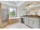 Bright bathroom featuring a soaking tub, walk-in shower, and vanity with a marble countertop at 3505 Watson Rd, Cumming, GA 30028