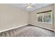 Bright bedroom features neutral walls, plush gray carpet, a ceiling fan, and a window with natural light at 3505 Watson Rd, Cumming, GA 30028