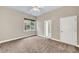 Neutral bedroom with soft carpet flooring, ceiling fan, and a window with view of trees at 3505 Watson Rd, Cumming, GA 30028