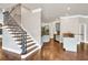 Bright foyer with staircase, hardwood floors, and entry into kitchen with light gray cabinets at 3505 Watson Rd, Cumming, GA 30028