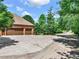 A three-car garage with brown doors and concrete driveway surrounded by green trees at 3505 Watson Rd, Cumming, GA 30028