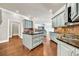 Open-concept kitchen featuring a center island, stainless steel appliances, and hardwood flooring at 3505 Watson Rd, Cumming, GA 30028