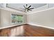 Spacious main bedroom featuring hardwood floors, a ceiling fan, and a large window at 3505 Watson Rd, Cumming, GA 30028