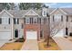 Three-unit townhome complex with brick and siding exteriors, featuring attached garages and landscaping at 438 Lantern Wood Dr, Scottdale, GA 30079