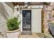 Back door with nearby potted plant, exterior lights, and stone accent wall at 250 Lakeview Ne Ave, Atlanta, GA 30305