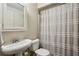 Functional bathroom with a pedestal sink, toilet, and shower with a decorative curtain at 250 Lakeview Ne Ave, Atlanta, GA 30305