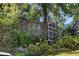 Exterior shot of home with screened porch surrounded by beautiful landscaping and a white picket fence at 250 Lakeview Ne Ave, Atlanta, GA 30305