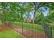Charming front yard of a house with black metal fence, manicured lawn, and mature trees, offering great curb appeal at 250 Lakeview Ne Ave, Atlanta, GA 30305