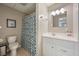 Clean basement bathroom with white vanity, shower, and patterned curtain at 412 Mallory Cir, Loganville, GA 30052