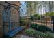 Blue metal bench nestled in garden next to black fence at 412 Mallory Cir, Loganville, GA 30052