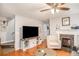 Living room with hardwood floors, fireplace, and large TV at 145 Gentle Breeze Ct, Temple, GA 30179