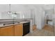 Modern kitchen with a breakfast bar, light wood cabinets, and black appliances at 285 Centennial Olympic Park Nw Dr # 1407, Atlanta, GA 30313