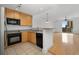 Modern kitchen with light wood cabinets, black appliances, and a breakfast bar at 285 Centennial Olympic Park Nw Dr # 1407, Atlanta, GA 30313