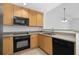Modern kitchen with light wood cabinets and black appliances at 285 Centennial Olympic Park Nw Dr # 1407, Atlanta, GA 30313