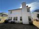 An exterior view of the back of the house, showcasing the chimney and the property's ample backyard space and windows at 308 Jarrod Oaks Ct, Loganville, GA 30052