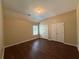 Bedroom with a large window, 2 closets, dark wood-look floors, and neutral walls at 308 Jarrod Oaks Ct, Loganville, GA 30052