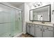 Bathroom featuring a double sink vanity, granite countertop, and a glass-enclosed shower at 7492 Knoll Hollow Rd, Lithonia, GA 30058