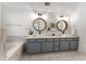 Bright bathroom featuring a dual sink vanity with gray cabinets, round mirrors, and marble countertops at 889 City Park Se Dr, Atlanta, GA 30312