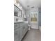 Bright bathroom with gray cabinets, a modern mirror, tile accents, and natural light from the window at 889 City Park Se Dr, Atlanta, GA 30312